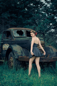 Woman standing by car on field