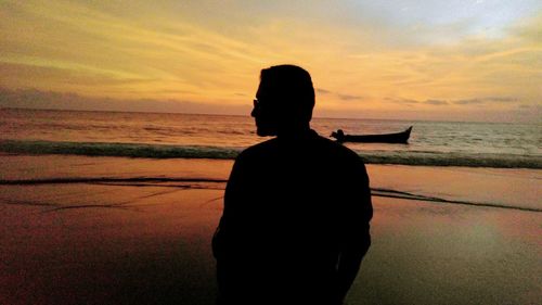 Rear view of silhouette woman against sea