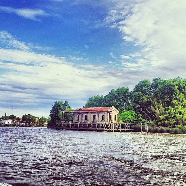 architecture, waterfront, water, built structure, building exterior, sky, tree, cloud - sky, rippled, cloud, river, house, nature, tranquility, tranquil scene, sea, lake, day, cloudy, outdoors