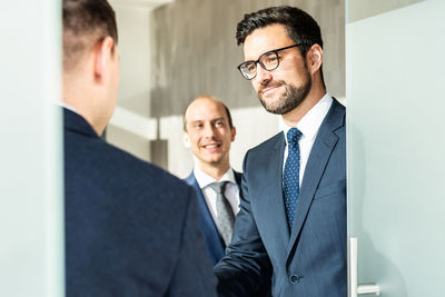 Group of confident business people greeting with a handshake at business meeting in modern office or
