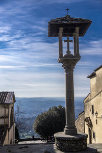 Gazebo on street by building against sky