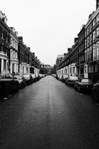 Cars on street amidst buildings against clear sky