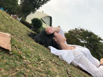 Surface level view of woman lying on grassy field