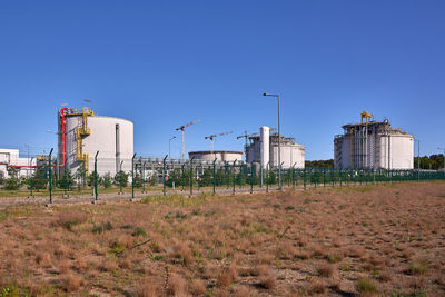 Houses on field against clear blue sky