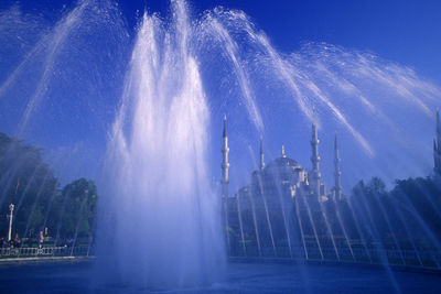 Panoramic view of fountain in city against sky