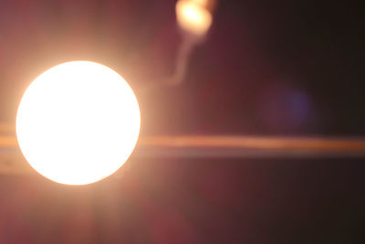 Close-up of illuminated lamp against sky