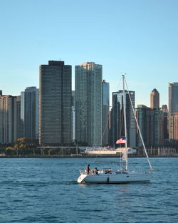 Boats in river with city in background