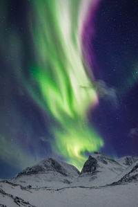 Scenic view of snowcapped mountains against sky at night