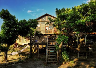 Abandoned building by trees against sky