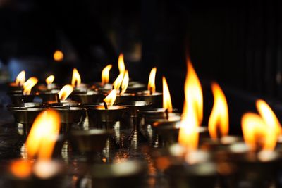 Close-up of burning diyas in temple