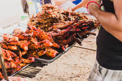 Midsection of man preparing food on barbecue grill