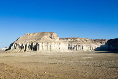 Rock formations in desert against clear blue sky