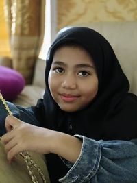 Portrait of young woman sitting at home