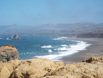 Scenic view of sea and mountains against sky