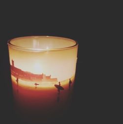 Close-up of illuminated tea light candle against black background