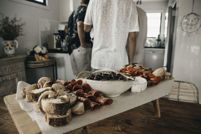 Rear view of man preparing food on table