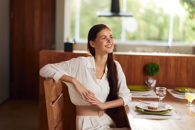 Portrait of young woman sitting at home