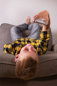 Rear view of man resting on sofa at home