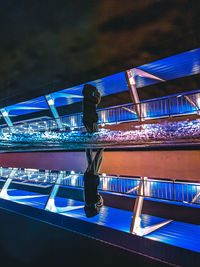 Rear view of man swimming in pool at night