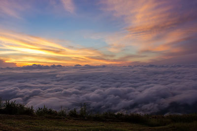 Scenic view of dramatic sky over land during sunset