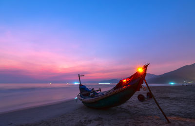 Fishing boat on sea against sky during sunset