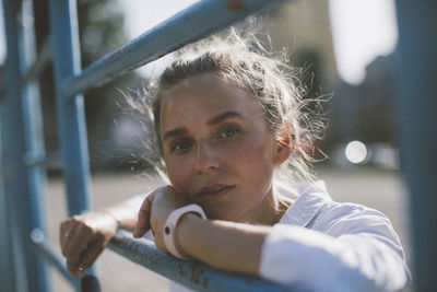 Portrait of young woman looking through window