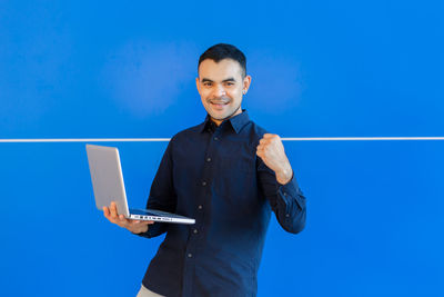 Portrait of smiling young man using smart phone