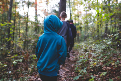 Rear view of man and woman standing in forest