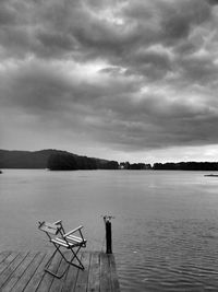 Pier on sea against cloudy sky