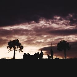 Silhouette of trees against cloudy sky