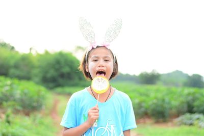 Portrait of cute boy holding ice cream against plants