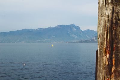 Scenic view of sea and mountains against sky