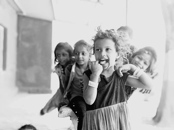 Portrait of happy girl standing against people