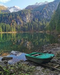 Boats moored on lake against mountains