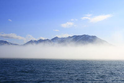 Scenic view of sea and mountains against sky