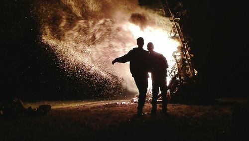 Silhouette man standing on water at night