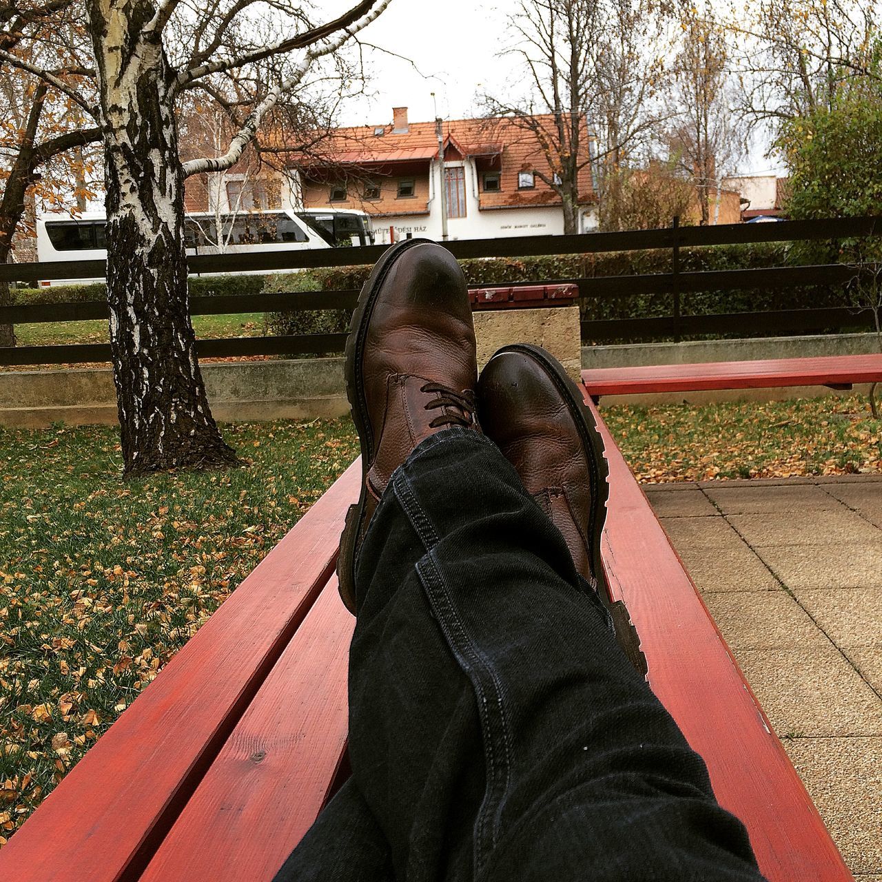 low section, lifestyles, tree, person, personal perspective, casual clothing, shoe, leisure activity, building exterior, standing, men, jeans, built structure, day, outdoors, park - man made space, architecture