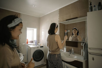 Morning beauty routine, two asian girls in bathroom preparing for skincare ritual