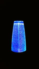 Low angle view of illuminated lighting equipment against black background