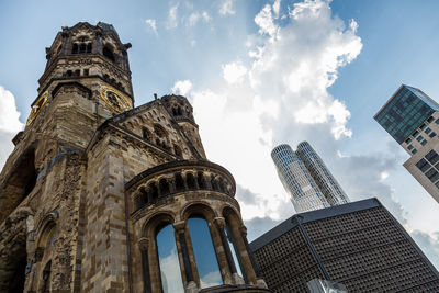 Low angle view of buildings against cloudy sky