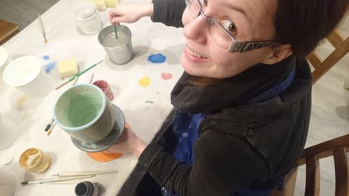 High angle view of woman holding drink on table