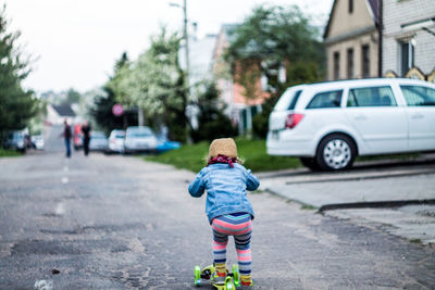 Rear view of boy on road in city