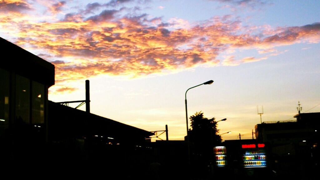 sunset, building exterior, architecture, built structure, silhouette, sky, low angle view, orange color, cloud - sky, street light, building, residential building, city, residential structure, house, dusk, cloud, cloudy, outdoors, no people