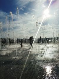 Man and wet umbrella against sky