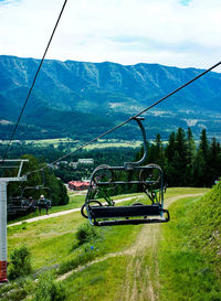 Ski lift in mountains against sky