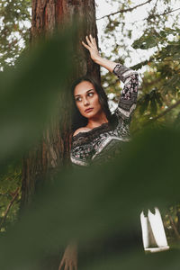 Portrait of young woman in tree trunk