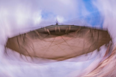 Digital composite image of woman against clouds