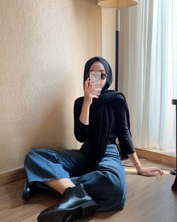 Portrait of young woman sitting on floor at home