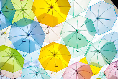 Full frame shot of multi colored umbrellas hanging against sky