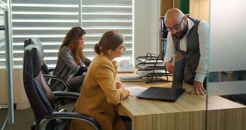 Businessman giving assignments to employee in modern office. 